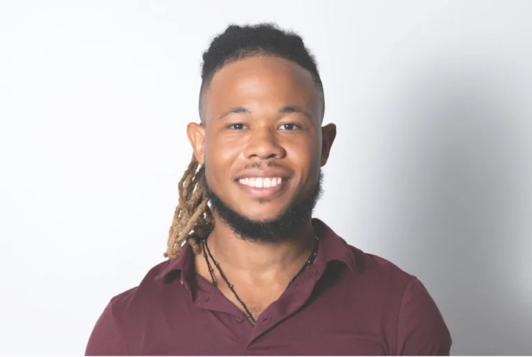 Chris Crawford, CEO of Dekhana Wellness Inc., smiling in a maroon shirt, representing expertise in wellness and holistic coaching.