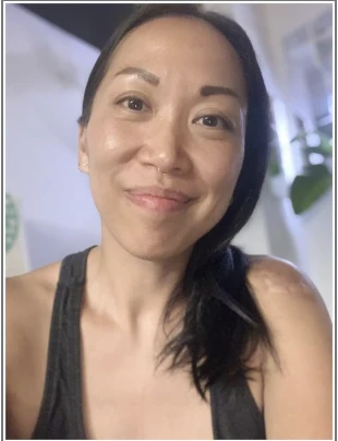 Mellisa Chung smiling in a fitness setting, embodying a holistic approach to movement and wellness, reflecting her background as a personal trainer and yoga teacher.